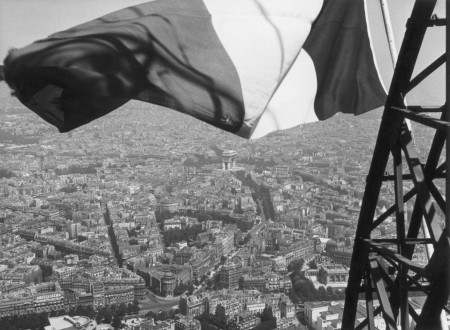 Photo of the tricolor flag raised at the top of the Eiffel Tower