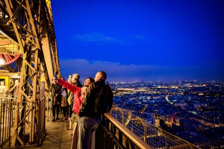 A couple taking a selfie with a glass of champagne on the 2nd floor of the Eiffel Tower